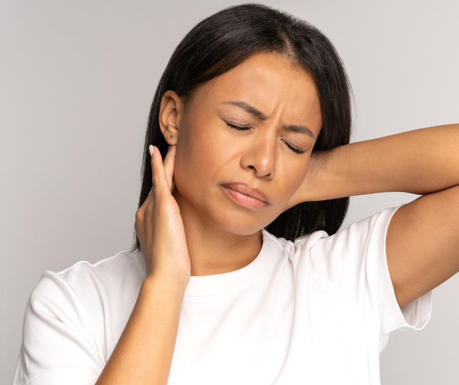 A woman with her eyes closed and a pained expression holds the side and back of her neck